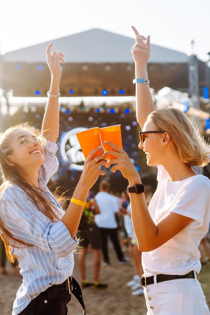 Amigas brindando em frente ao palco