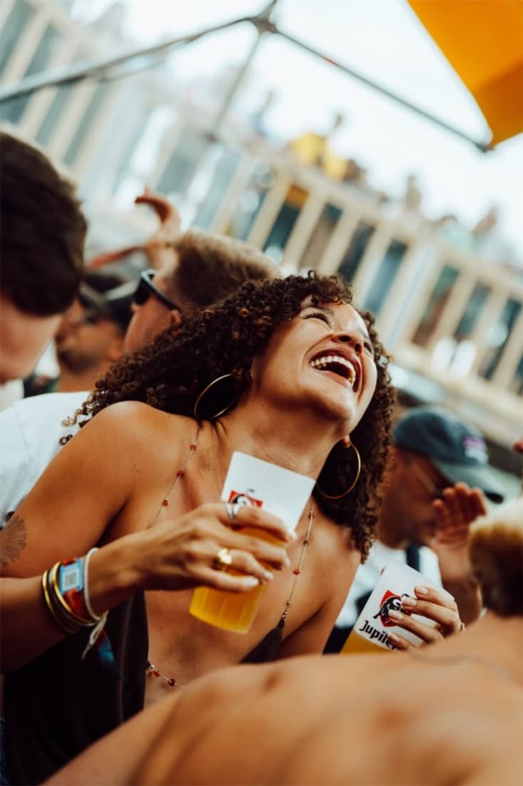 Mulher sorrindo com copo na mão
